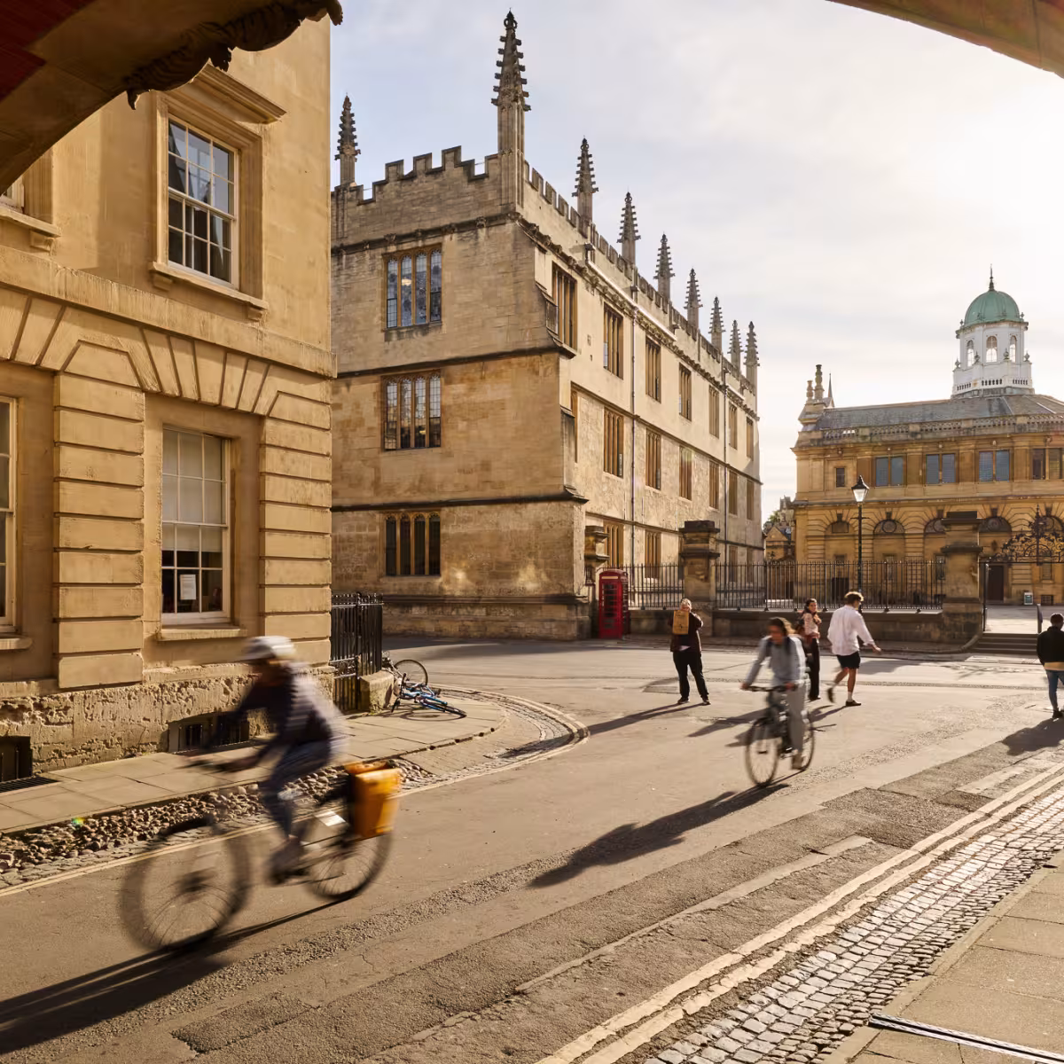 Cyclists passing under Hertford College's Bridge of Sighs in Oxford